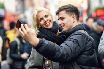 Happy couple of tourists taking selfie in a crowded street of London. Happy couple of tourists taking selfie in a crowded street.