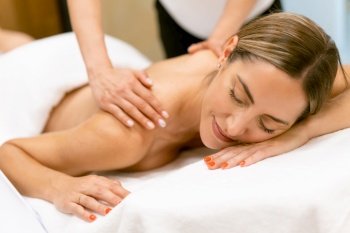 Middle-aged woman having a back massage in a beauty salon. Body care treatment in a beauty centre.. Middle-aged woman having a back massage in a beauty salon.