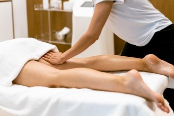 Middle-aged woman having a leg massage in a beauty salon. Body care treatment in a beauty centre.. Middle-aged woman having a leg massage in a beauty salon.