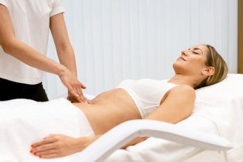 Middle-aged woman having a belly massage in a beauty salon. Body care treatment in a beauty centre.. Middle-aged woman having a belly massage in a beauty salon.