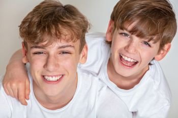 White background studio photograph of young happy boy children brothers smiling together