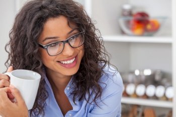 Beautiful Latina Hispanic girl or young woman smiling, relaxing and drinking a cup of coffee or tea