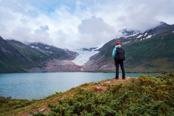 Girl tourist looks at a glacier. Svartisen Glacier in Norway. Beautiful Nature Norway.