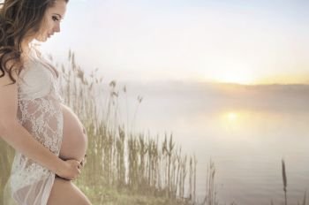 Calm pregnant woman relaxing by the lake