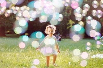 Portrait of a little lady playing the soap bubbles