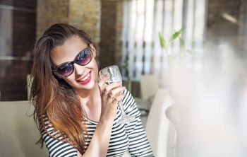Closeup portrait of a young female customer drinking a glass of white wine