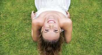 Portrait of a beautiful young woman laying on the summer lawn