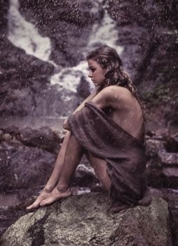 Sensual lady resting near to the waterfall