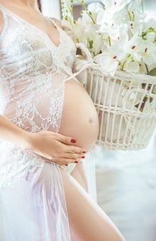 Pregnant woman holding a basket full of flowers