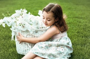 Sweet little girl holding a basket full of flowers