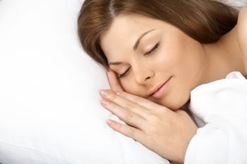Portrait of the beautiful sleeping woman in white bed

