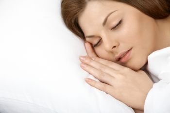 Portrait of the beautiful young woman sleeping in white bed
