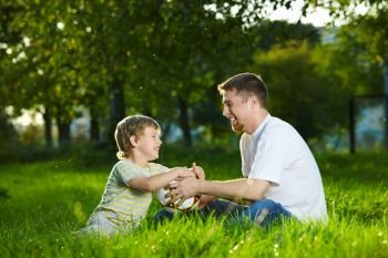 Conversation of father and small son in a summer garden