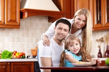 Happy parents with the child on kitchen