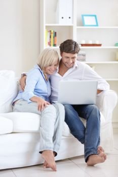 Mature happy couple with laptop at home