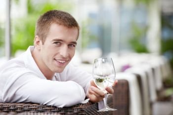 A young man with a glass in the cafe