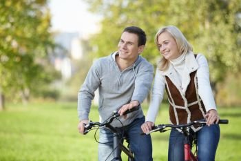 Smiling couple on bicycles in the park