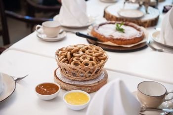 Traditional russian baked goods: pies and pretzels, samovar, honey, jam on the served table. Traditional russian baked goods