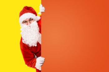 Santa Claus is looking out of colorful advertisement board and copy space. Santa Claus with colorful advertisement board