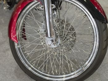 Beautiful nickel plated front wheel of a red motorcycle.. Beautiful nickel plated front wheel of a red motorcycle
