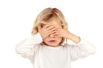 Sad blond child covering the face with his hands isoalted on a white background