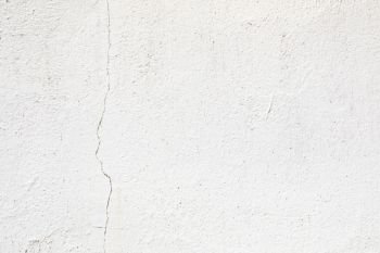 Crack in a white wall with cement brick surface