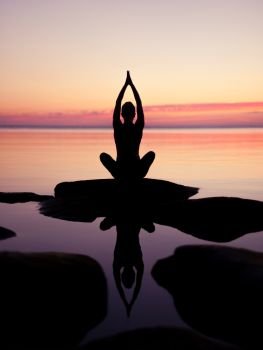 caucasian fitness woman practicing yoga on the beach at sunset. caucasian fitness woman practicing yoga
