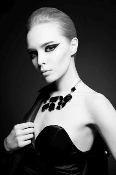 Fashion studio photo of beautiful stylish woman with bright makeup and black accessories. Fashion arrow shape. Rock and roll style