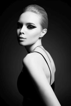 Fashion studio photo of beautiful stylish woman with bright makeup and black accessories. Fashion arrow shape. Rock and roll style