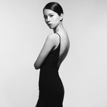 Fashion studio portrait of beautiful woman in black evening dress. Asian beauty.