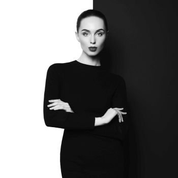 Fashion art studio portrait of elegant woman in geometric black and white background. Professional makeup with black lipstick. Stylish classic dress.