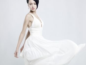 Fashionable photo of beautiful young lady in a billowing white dress