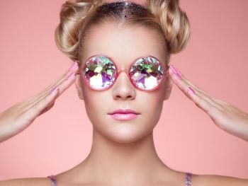Portrait of Beautiful young Woman with Colored Glasses. Beauty Fashion. Perfect Make-up. Pink Nails Manicured. Colorful Decoration. Hair Curled into a Bun