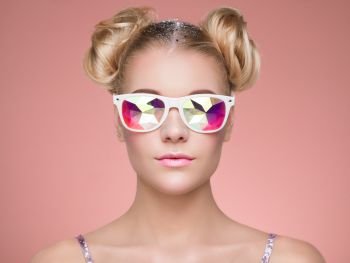 Portrait of Beautiful young Woman with Colored Glasses. Beauty Fashion. Perfect Make-up. Colorful Decoration. Hair Curled into a Bun