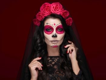 Portrait of a woman with sugar skull makeup over red background. Halloween costume and make-up. Portrait of Calavera Catrina