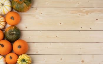 Many orange pumpkins on light wooden background , Halloween concept , top view with copy space. Pumpkins on wooden background