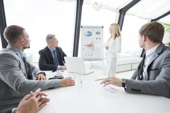 Businesswoman pointing at a chart on a whiteboard during business meeting. Business presentation on whiteboard