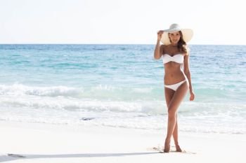 Woman in bikini and sunhat on the beach. Woman on the beach