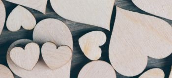 Many wooden colorless hearts background. Wooden hearts background