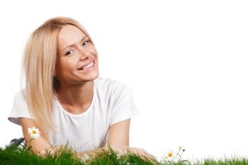 Beautiful young blonde woman lying on grass with chamomile flowers, isolated on white background. Woman on grass with flowers