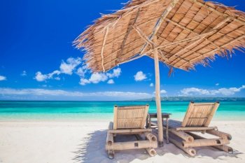 Beach chairs and umbrella on a beautiful tropical sea beach, view with copy space. Beach chairs and umbrella