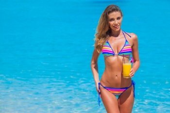 Beautiful slim woman in bikini with cocktail at seaside. Woman in bikini with cocktail