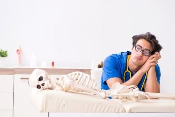 Funny doctor with skeleton in hospital