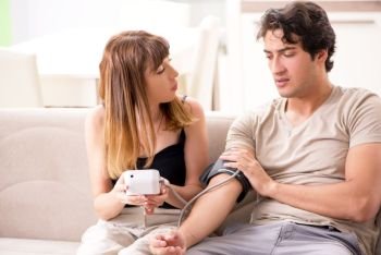 Wife checking husband’s blood pressure  . Wife checking husband’s blood pressure 