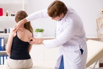 Female patient visiting young handsome doctor chiropractor . The female patient visiting young handsome doctor chiropractor 