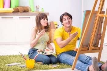 Young couple enjoying painting at home. The young couple enjoying painting at home