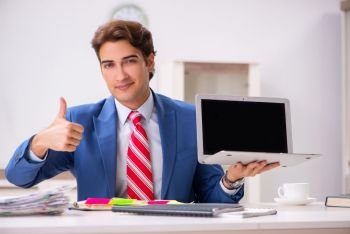 Young attractive businessman working in the office  . The young attractive businessman working in the office  