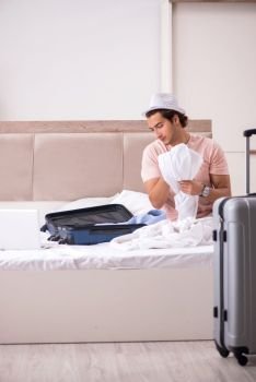 Man with suitcase in bedroom waiting for trip 