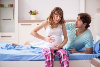 Pregnant woman with husband in the bedroom 