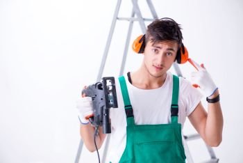 Young worker with earmuffs in noise cancelling concept 